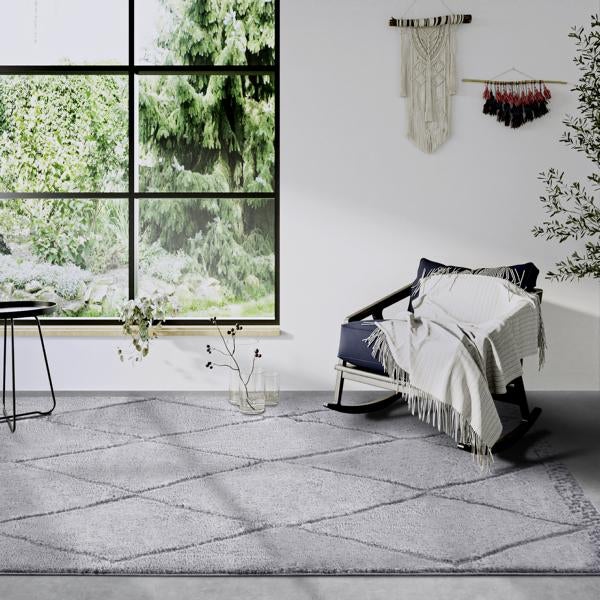 Grauer Teppich mit geometrischem Muster in einem Wohnzimmer.