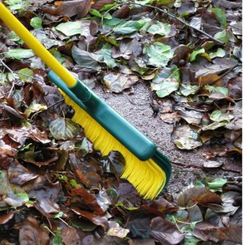 Laubbesen mit Stiel im Einsatz zum Entfernen von Blättern.
