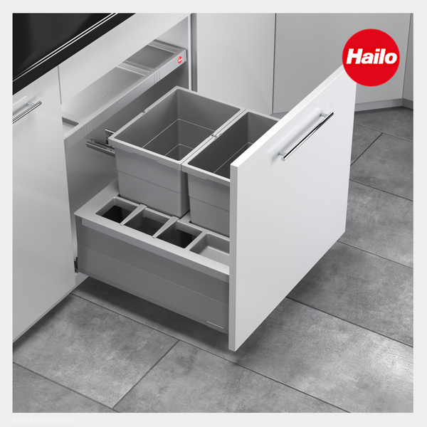 Hailo Logo. Ausgezogene Küchenschublade mit einem Mülltrennsystem bestehend aus zwei großen grauen Behältern und mehreren kleinen Fächern.