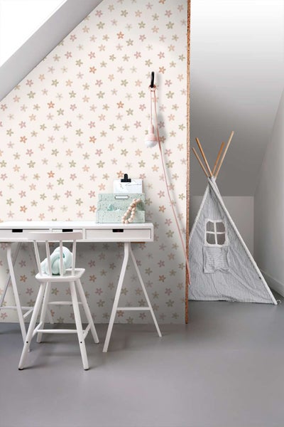 Kindertapete mit Blumenmuster an einer Wand im Kinderzimmer mit Schreibtisch, Stuhl und einem Tipi Zelt.