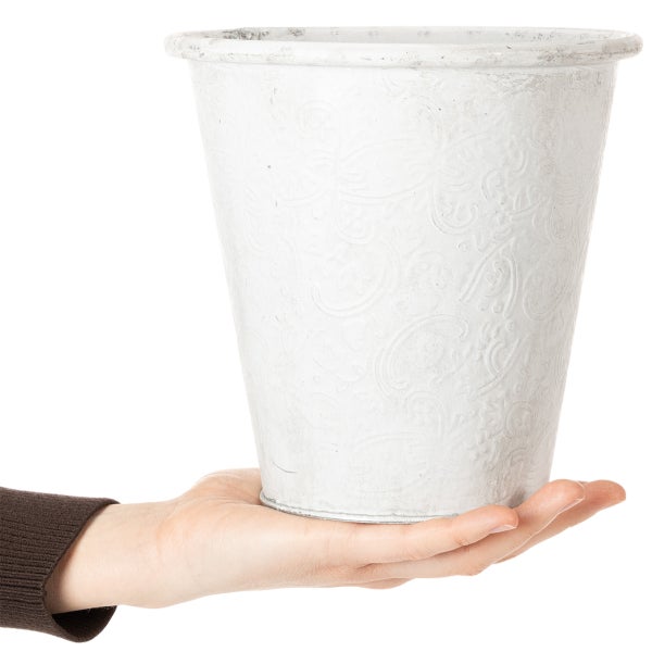 Weißer Blumentopf aus Zink mit Ornament-Relief, zur Größendarstellung auf einer Hand präsentiert.