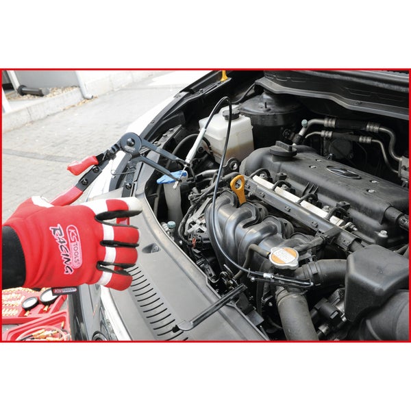 Motorraum eines Autos mit Schlauchschellen-Zange im Einsatz