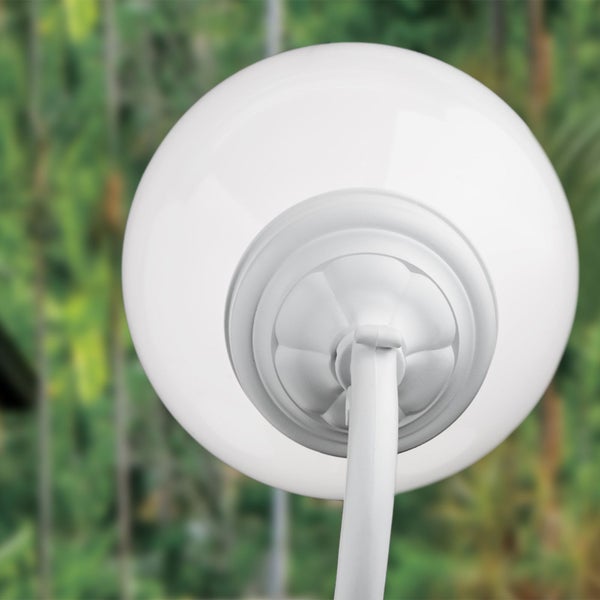 Weiße Außenkugelleuchte mit dekorativer Halterung in einem Garten.