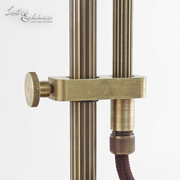 Detailaufnahme einer Messinglampe mit verstellbarem Gelenk und Textilkabel