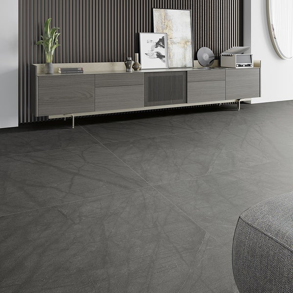 Moderne graue Bodenfliesen in Steinoptik mit feiner Maserung in einem elegant eingerichteten Wohnzimmer mit Sideboard.
