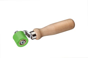 Andrückroller mit ergonomischem Holzgriff, Metallbügel und kleiner grüner Kunststoffrolle.