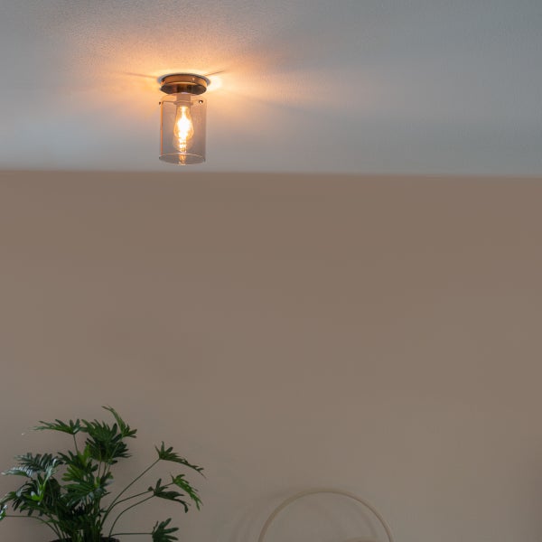 Deckenleuchte mit durchsichtigem, zylindrischem Glasschirm.