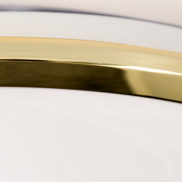 Detailaufnahme einer goldenen Zierleiste auf einem weißen Untergrund.