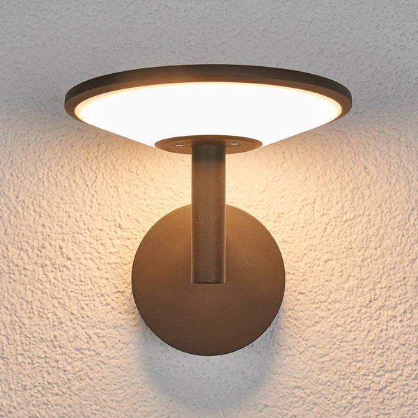 Moderne Außenwandleuchte aus Metall in Anthrazit mit flachem, rundem Schirm und warmem Licht.