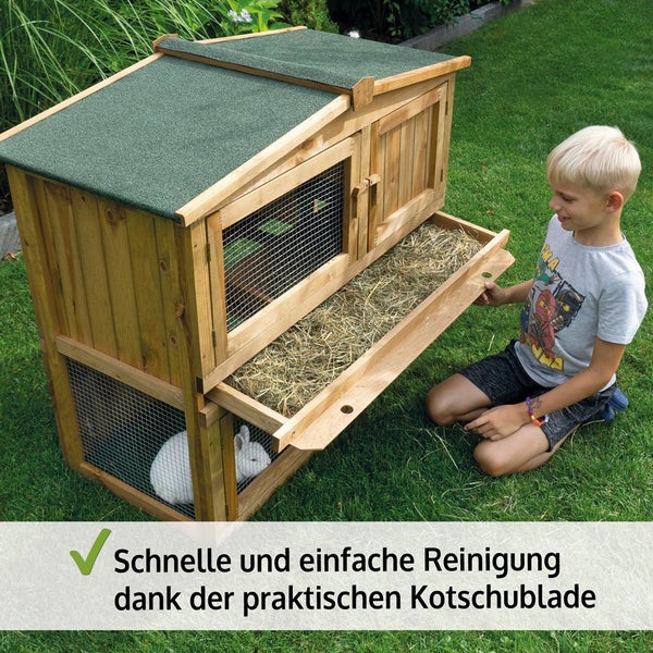 Zweistöckiger Kleintierstall aus Holz im Garten mit Kaninchen, einer ausziehbaren Reinigungsschublade für einfache Säuberung und einem Kind daneben.