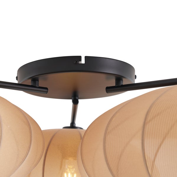 Nahaufnahme einer Deckenleuchte mit schwarzer Metallhalterung und braunen lichtdurchlässigen Schirmen.