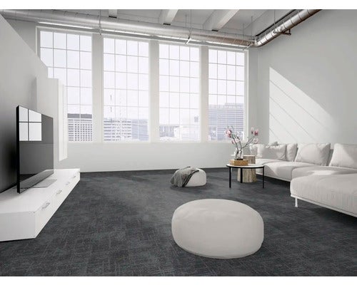 Modernes Wohnzimmer mit dunklen Teppichfliesen, hellem Ecksofa, großen Fenstern und Decke im Industriestil.