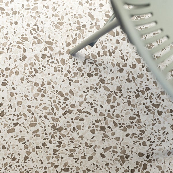 Bodenfliese mit Terrazzo Optik in einer modernen Inneneinrichtung mit einem Stuhlbein.
