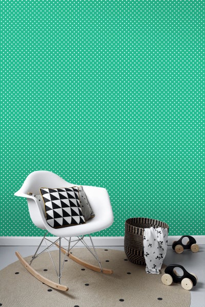 Kinderzimmer mit gepunkteter Tapete, Schaukelstuhl und Spielzeug
