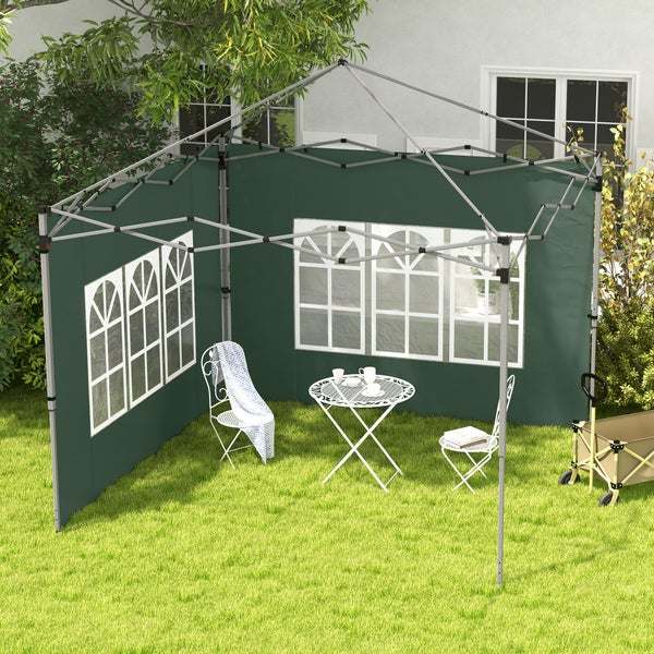 Grüner Faltpavillon mit Seitenwänden und Sprossenfenstern, aufgestellt auf einem Rasen mit weißem Gartenmöbel-Set und einem Bollerwagen.
