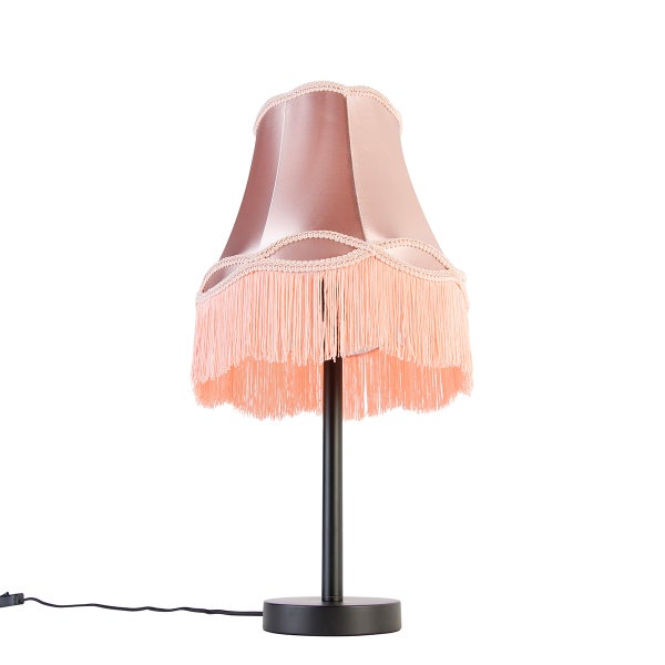 Tischleuchte im Vintage-Stil mit Textilschirm, Fransenbesatz und schwarzem Metallfuß.