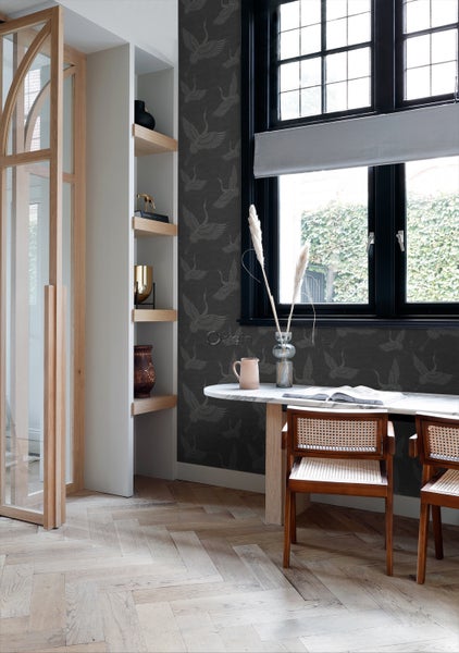 Innenraum mit Regal, Tisch und Tapete mit Vogelmuster.