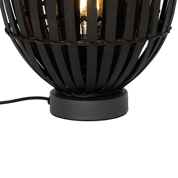 Nahaufnahme einer Tischleuchte mit schwarzem Bambusschirm und rundem Fuß