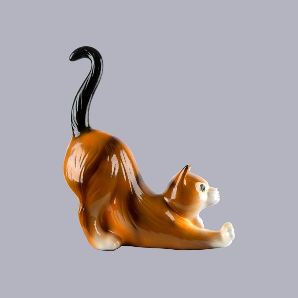 Dekofigur Katze aus Keramik in Braun, Schwarz und Weiß, in einer Streckposition mit erhobenem Schwanz und glänzender Oberfläche.