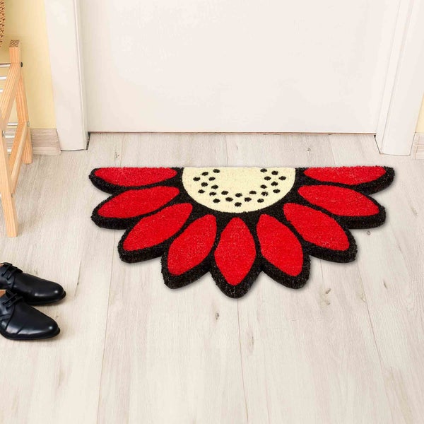 Blumenförmige Fußmatte vor einer Tür.