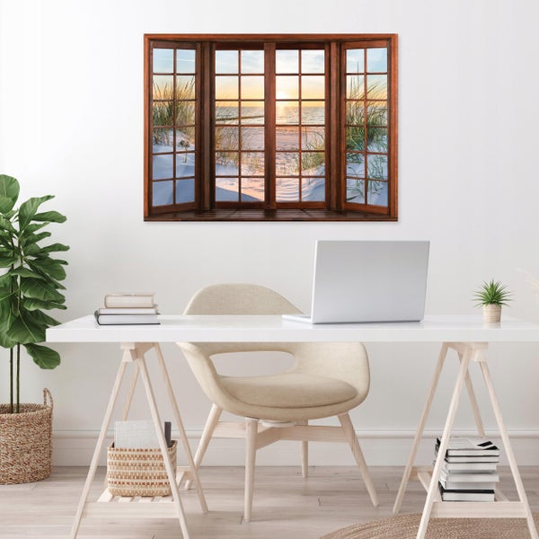 Wandbild mit Fenstermotiv, Blick auf Strand und Meer bei Sonnenuntergang, in einem hellen Büro über einem weißen Schreibtisch.
