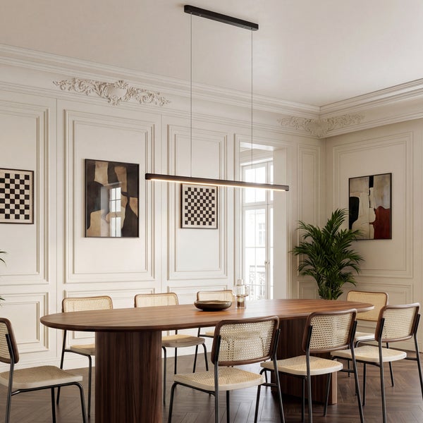 Moderner, heller Essbereich mit ovalem Holztisch, Rattanstühlen und einer schwarzen linearen LED-Pendelleuchte über dem Tisch.