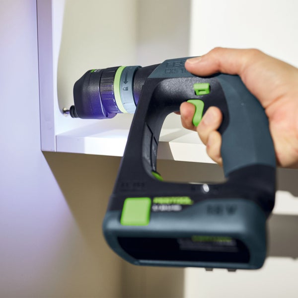 Eine Person bohrt mit einem Akku-Bohrschrauber ein Loch in ein Holzstück.