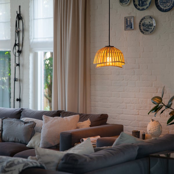 Wohnzimmer mit grauer Couch und einer Pendelleuchte aus Holz