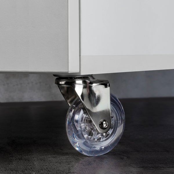 Möbelrolle transparent mit Metallhalterung montiert an der Unterseite eines weißen Schranks.