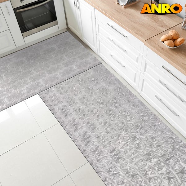 Küchenszene mit zwei gemusterten Teppichen vor weißen Küchenschränken