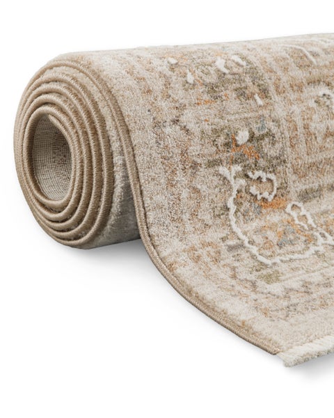 Aufgerollter Kurzflor-Teppich in Beige mit orientalischem Muster.