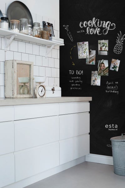Küchenszene mit Tafelwand, Küchenutensilien und weißer Küchenzeile.