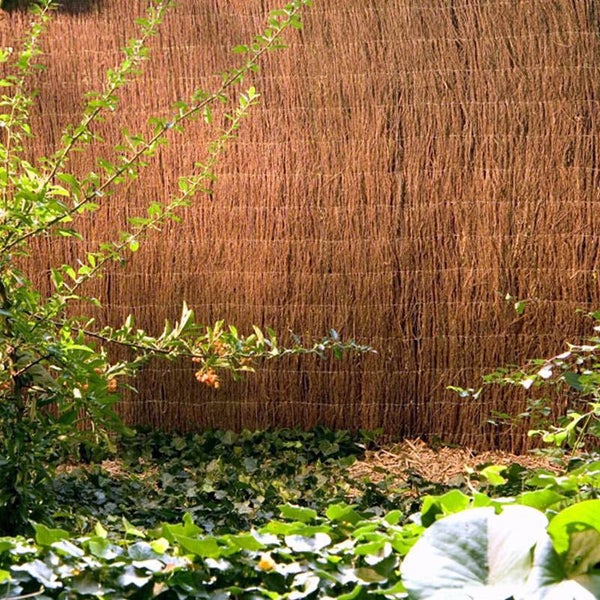 Gartenszene mit Sichtschutzzaun aus Naturmaterialien und grünen Pflanzen