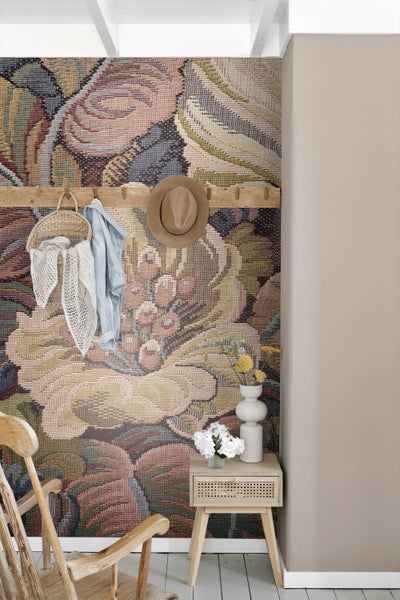 Vliestapete mit großem floralem Gobelinmuster im Landhausstil, kombiniert mit Holzmöbeln und Dekoration in einem hellen Raum.