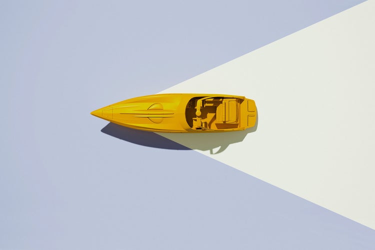 Gelbes Spielzeugboot auf zweifarbigem Hintergrund