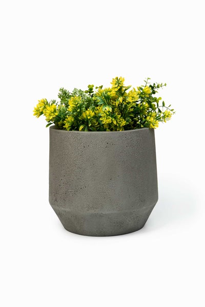 Grauer Blumentopf in Betonoptik mit künstlichen gelben Blumen.