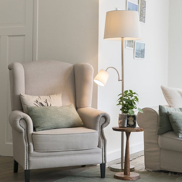 Wohnzimmer mit Sessel, Stehlampe und Beistelltisch