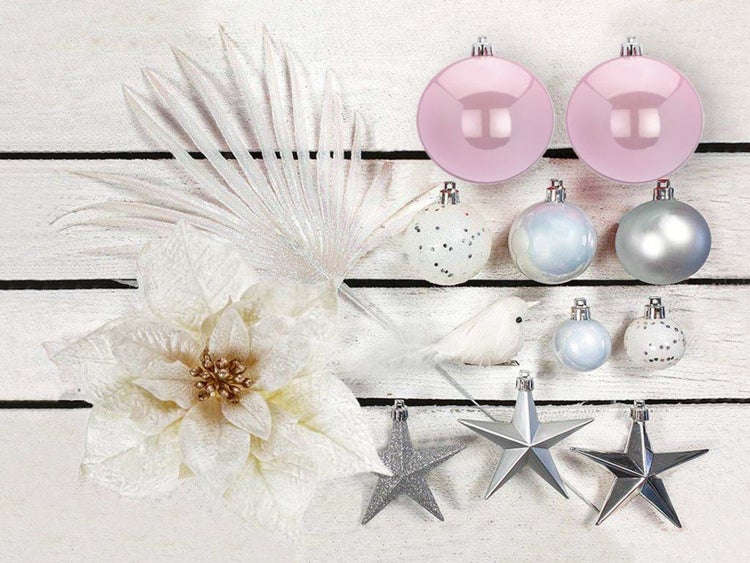 Weihnachtsschmuck Set bestehend aus Christbaumkugeln, Sternen, einer künstlichen Blume und einer Vogelfigur auf Holzoptik Untergrund