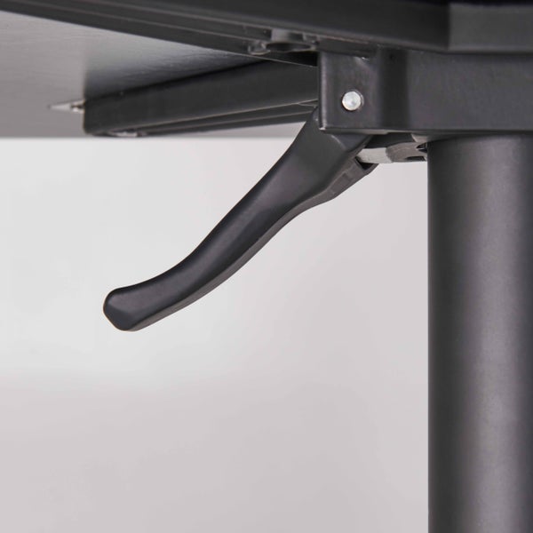 Detail eines schwarzen Hebels zur Höhenverstellung unter einer Tischplatte.