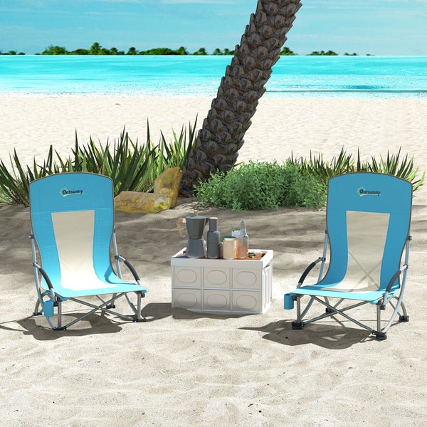 Zwei faltbare Outsunny Strandstühle am Sandstrand neben einer Palme mit einem Beistelltisch und Kaffeekanne in hellem Außenbereich.