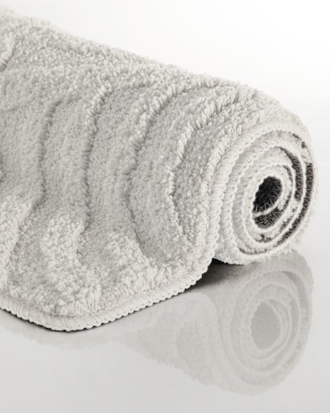 Gerollte Badematte mit Hochflor und strukturierter Wellenoberfläche.