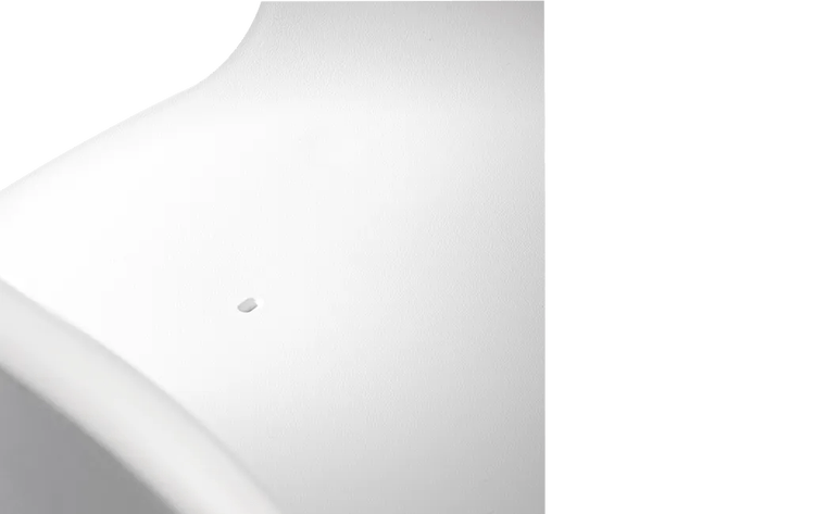 Nahaufnahme einer weißen, strukturierten Oberfläche mit einer kleinen Öffnung.