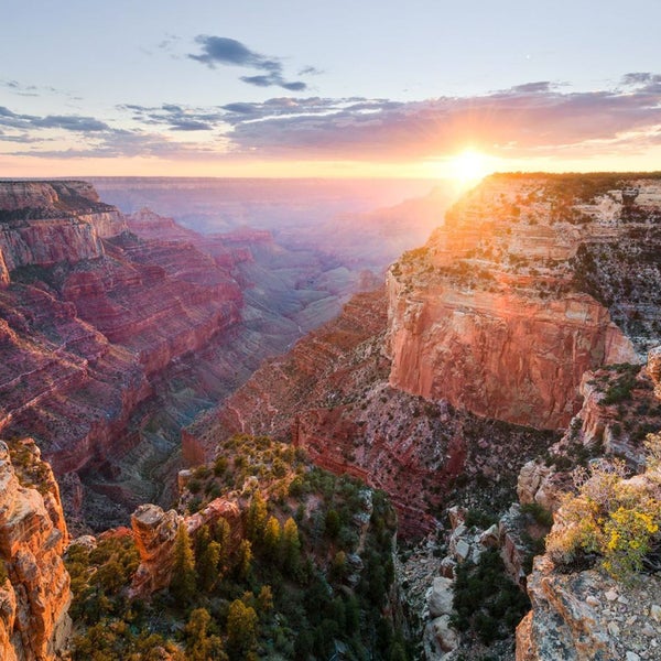 Sonnenaufgang über dem Grand Canyon mit Felsen und Vegetation