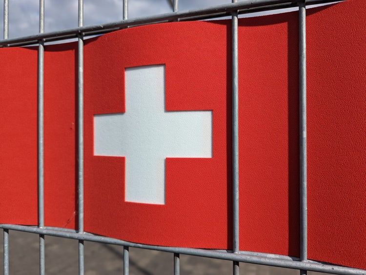 Schweizer Flagge an einem Zaun