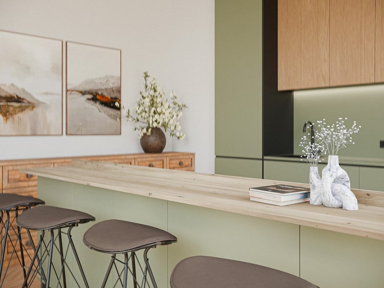Moderne Küche mit einer hellgrünen Kücheninsel mit Arbeitsplatte aus hellem Holz, Barhockern und passenden Einbauschränken.