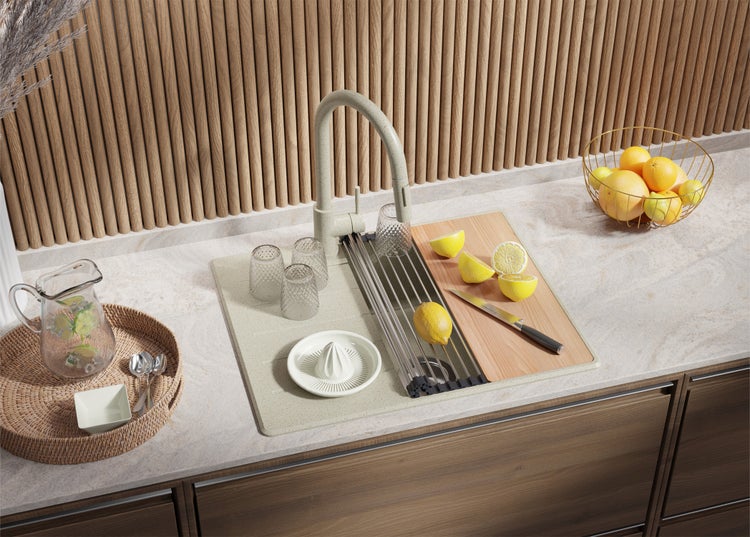 Küchenszene mit Spüle, Armatur, Gläsern, Zitronen, Schneidebrett und dekorativen Elementen für eine helle, organisierte Atmosphäre.