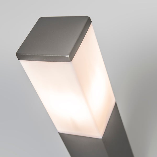 Moderne quadratische Außenleuchte aus anthrazitfarbenem Metall mit weißem Kunststoffdiffusor, eingeschaltet.