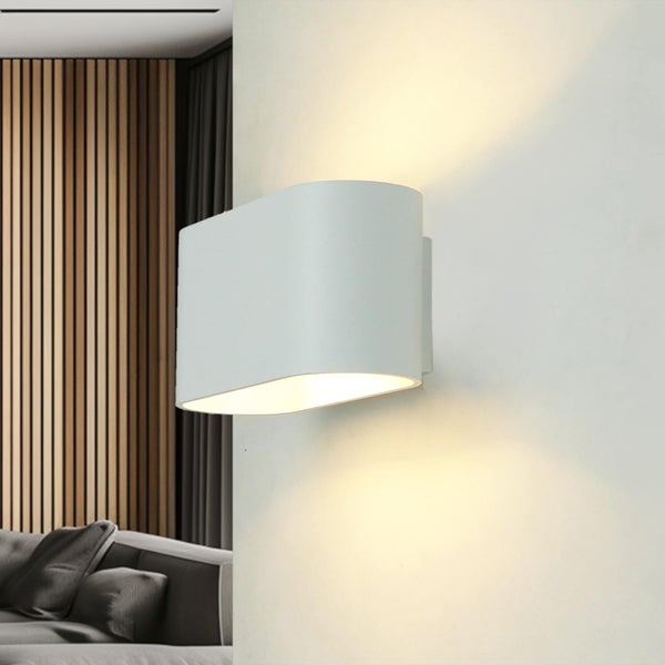Moderne Wandleuchte mit Lichtaustritt nach oben und unten an einer Wand montiert in einem Wohnzimmer.