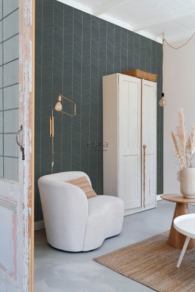 Gemütliches Zimmer mit Tapete, Sessel und Schrank