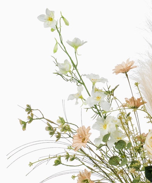 Künstlicher Blumenstrauß mit weißen und pfirsichfarbenen Blüten sowie grünen Stielen und Blättern.